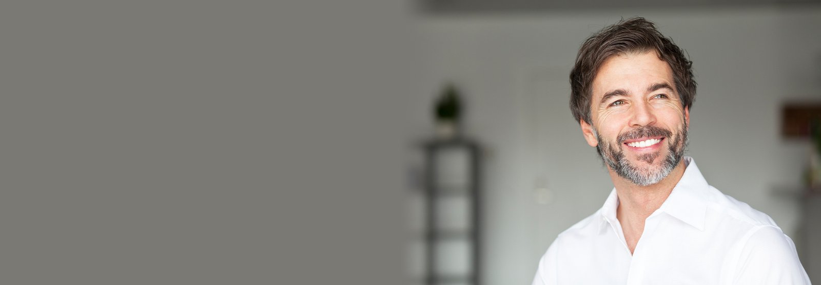 Handsome man smiling with salt and pepper hair and beard