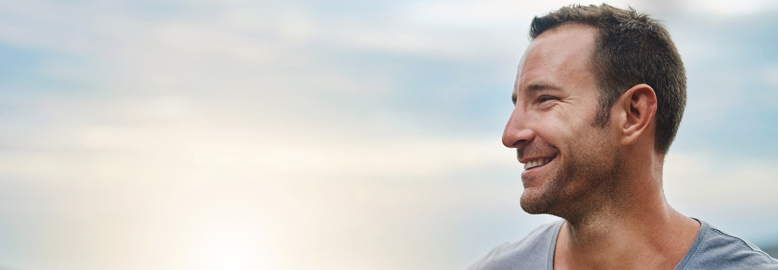 Man smiling, looking to the side 