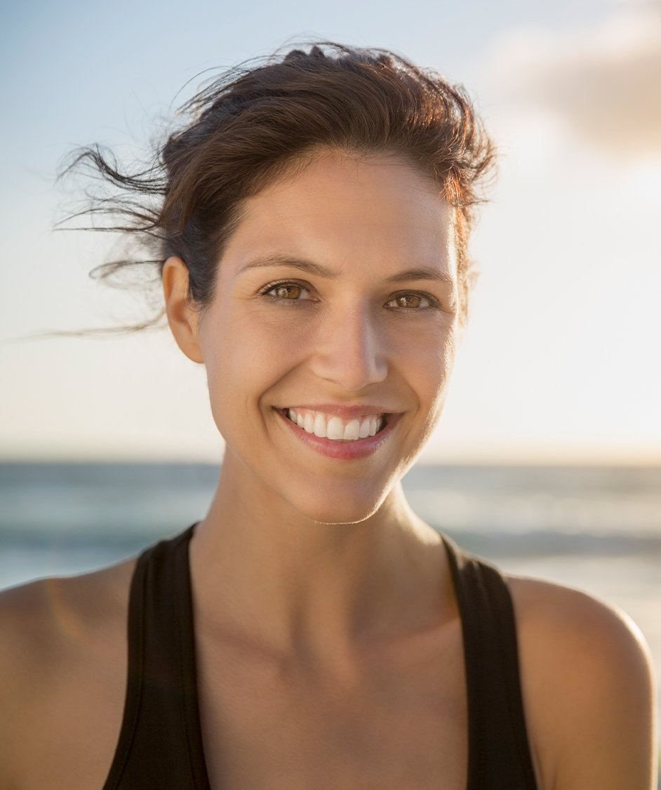woman smiling with the ocean in the background