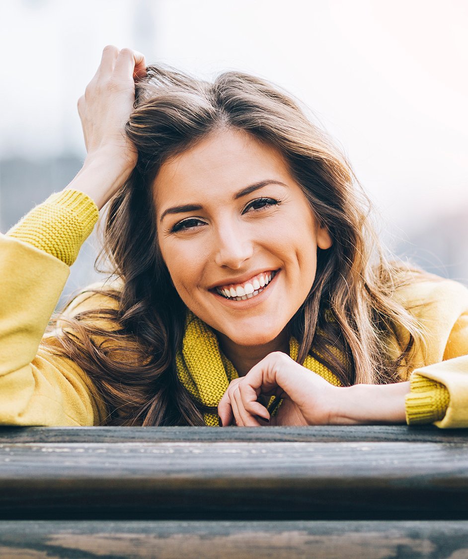 Woman in a yellow sweater smiling