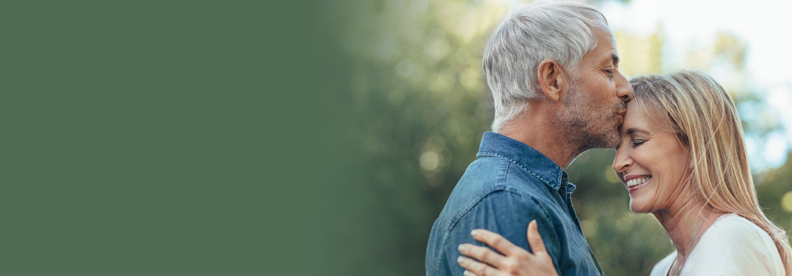 man kissing a woman's forehead
